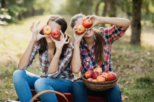 deux filles rigolent avec pommes